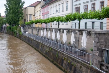Yağmur sırasında nehrin kenarında küçük, rahat bir restoranın yaz terası.