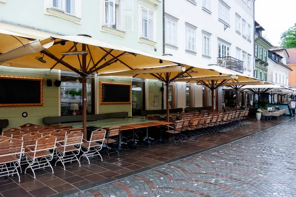 Yağmur sırasında nehrin kenarında küçük, rahat bir restoranın yaz terası.