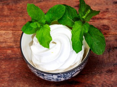 Ahşap bir masada porselen bardakta naneli el yapımı limon şekerlemesi.