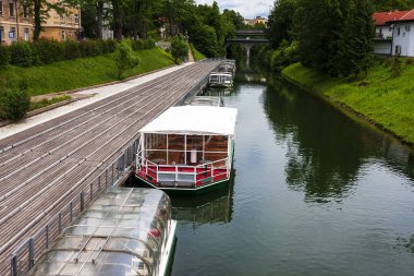 Zevkli tekneler Ljubljana nehrinin rıhtımında duruyor.