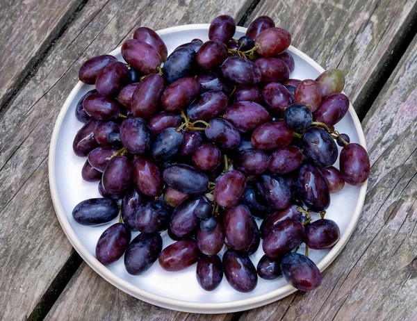 Plato Con Uvas Rojas Frescas Sobre Una Vieja Mesa Madera — Foto de Stock