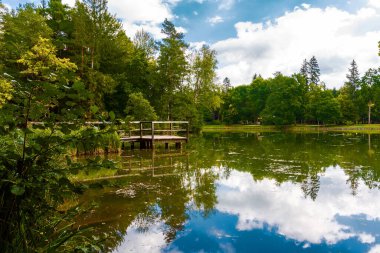 Bulutlar bir dağ gölünün suyuna yansıyor.