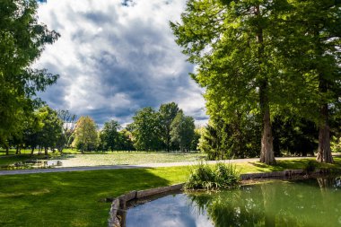 Parktaki dağ gölü mavi gökyüzündeki bulutların arka planına karşı.