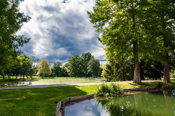 Parktaki dağ gölü mavi gökyüzündeki bulutların arka planına karşı.