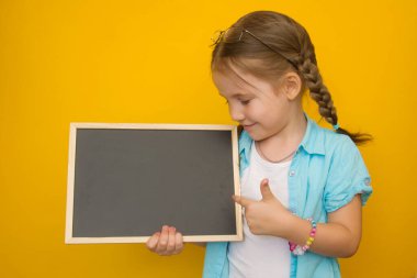 Okula dönelim. At kuyruklu neşeli küçük bir kız elinde mesaj atabileceği bir yer olan okul tahtasını tutuyor ve sarı bir arka planda işaret ediyor.