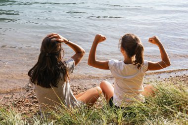 İki kız kardeş göl kenarında oyun oynadılar ve küçük kız kazandı.