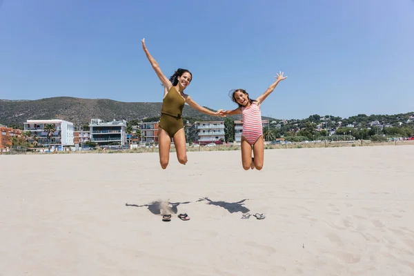 Dos Chicas Saltando Playa Edificios Ven Fondo — Foto de Stock