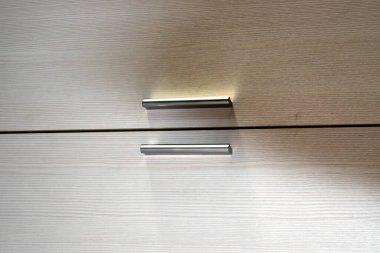 Dolap kapaklarında iki metal kol var.