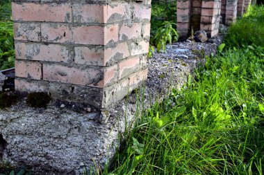 Çimlerle kaplı tuğla sütunlar