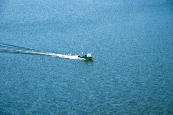 Зелений моторний човен рухається вздовж поверхні блакитного моря — стокове фото