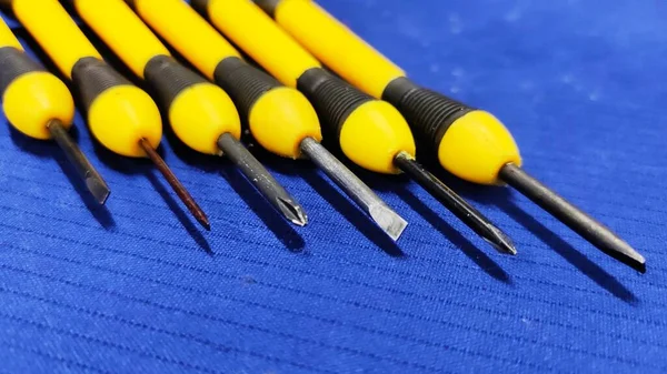 Mavi desenli arka planda küçük vida sürücü mini kesinlik seti.