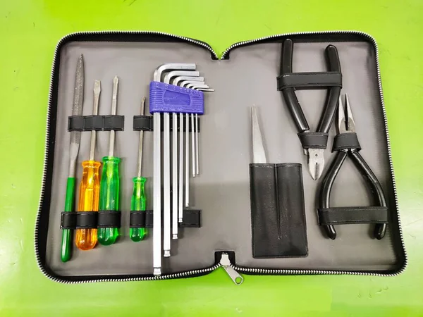 Borsa Small Tools aperta vista dall'alto per elettricista e montatore con strumenti su sfondo verde . — Foto Stock