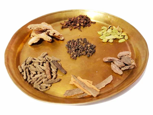 Ayurvedik şifalı bitkiler beyaz arka plan görünümlü pirinç plaka üzerinde ilaç malzemeleri