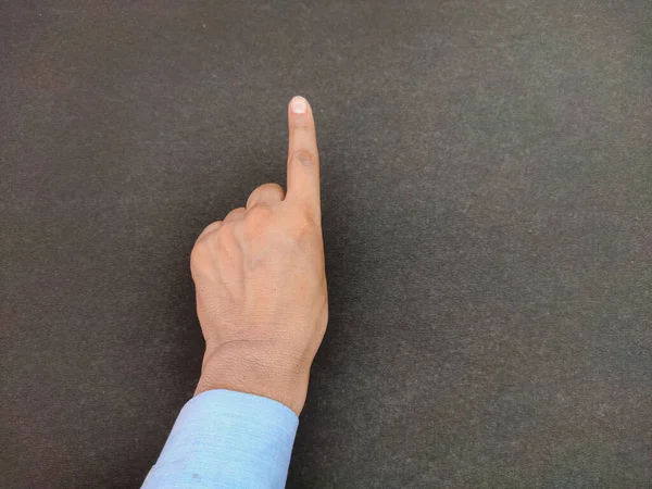 Siyah arkaplanda bir numarayı saymanın dışa dönük bir işaretini gösteren izole bir el..