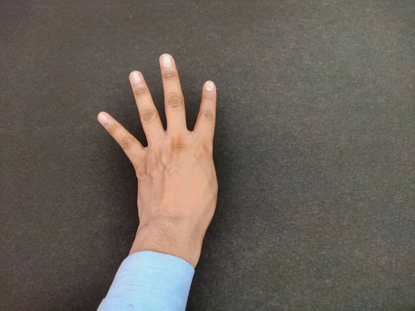 Одна открытая рука без большого пальца Изолированный вид сзади с протянутыми пальцами, показывающими жест четыре, концепция образования, инвалидность левой руки на черном фоне — стоковое фото