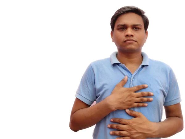 Young Indian man wearing casual T-shirt standing over White background with hands on chest and grateful gesture on face. Health concept. — Stock Photo, Image
