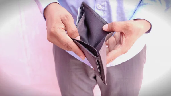 Hombre mano abrir una cartera vacía sobre fondo claro — Foto de Stock