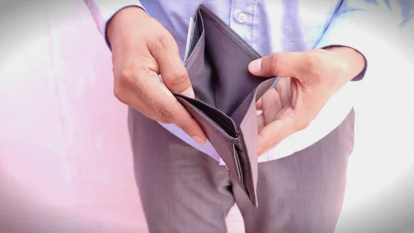 Hombre mano abrir una cartera vacía sobre fondo claro Imagen De Stock