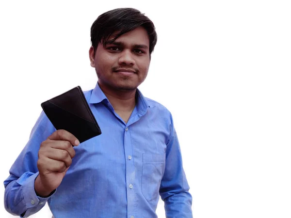 Νεαρός άνδρας με μπλε πουκάμισο κρατώντας πορτοφόλι γεμάτο χαίτη είναι ευτυχής, δείχνει τσάντα, ινδός άνθρωπος, απομονώνονται σε λευκό φόντο — Φωτογραφία Αρχείου