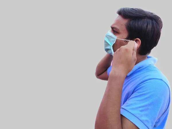 Mann mit Mundschutz in der Hand wird zum Schutz gegen Coronavirus getragen — Stockfoto