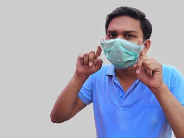 Jeune homme en T-shirt bleu porte un masque facial pour la protection contre la propagation de l'épidémie de corona. — Photo