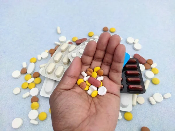 Tabletták és tabletták a kézben a betegség kezelésére, gyógyszerek a háttérben, szelektív fókusz. — Stock Fotó