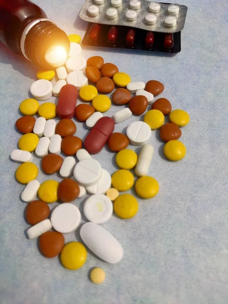 Пляшка таблеток на синьому фоні для лікування хвороб, таблетки поширюються на папері з місцем для тексту — стокове фото