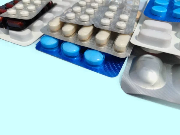 A beteg betegek kezelésére használt gyógyszertabletták és tabletták papírra szórva. — Stock Fotó