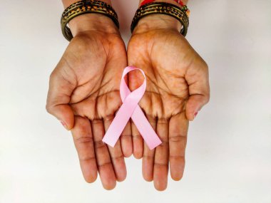 Eli pembe kurdele tutan kadın, göğüs kanseri farkındalığı sembolü, kanserle mücadele.