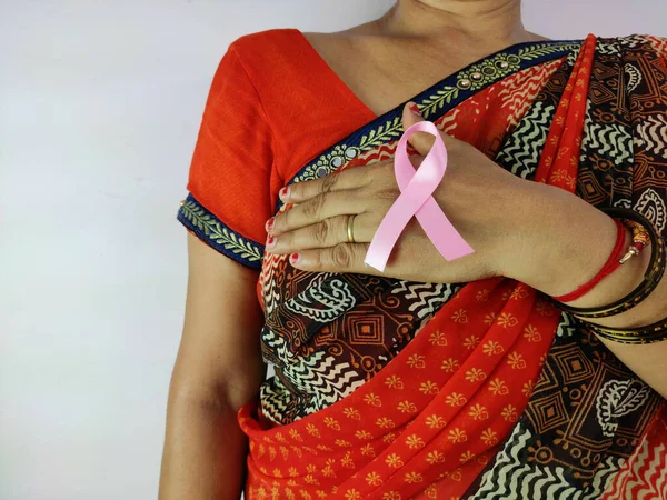 Mulher indiana Mão segurando fita rosa, símbolo de consciência de câncer de mama, luta contra o câncer Fotografia De Stock