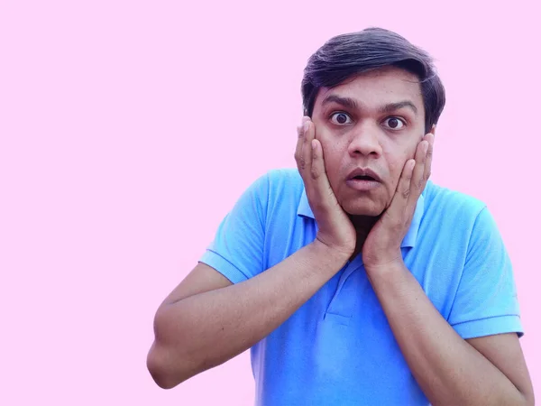 Shocked or surprised young man put his hand on cheeks , copy space — Stock Photo, Image