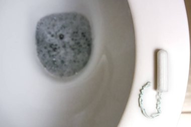 Tuvalet oturağında tampon var. Yabancı nesneler, hijyenik pedler, tamponlar, kağıt, plastik..