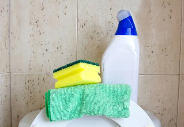 Detergent bottle, sponge and rag. Cleaning supplies in wc bathroom toilet interior backgrount. Home cleaning service concept.