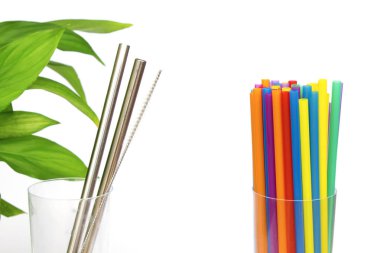 Plastik, eko çelik kamışa karşı. Özel fırçalı, yeşil yapraklı ve beyaz arka planda birçok renkli pipetli sürdürülebilir metal kokteyl çubuğu. Sıfır atık.