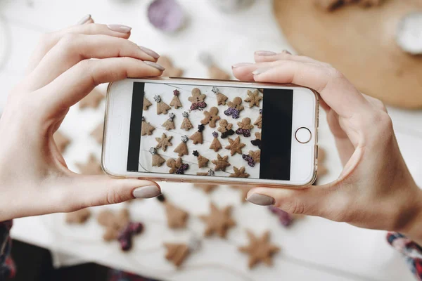甘いクッキーとテーブルの上の梨花の手で水平の電話 — ストック写真