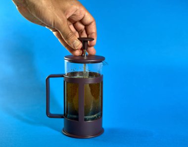 Mavi arka planda çay yapan kişi