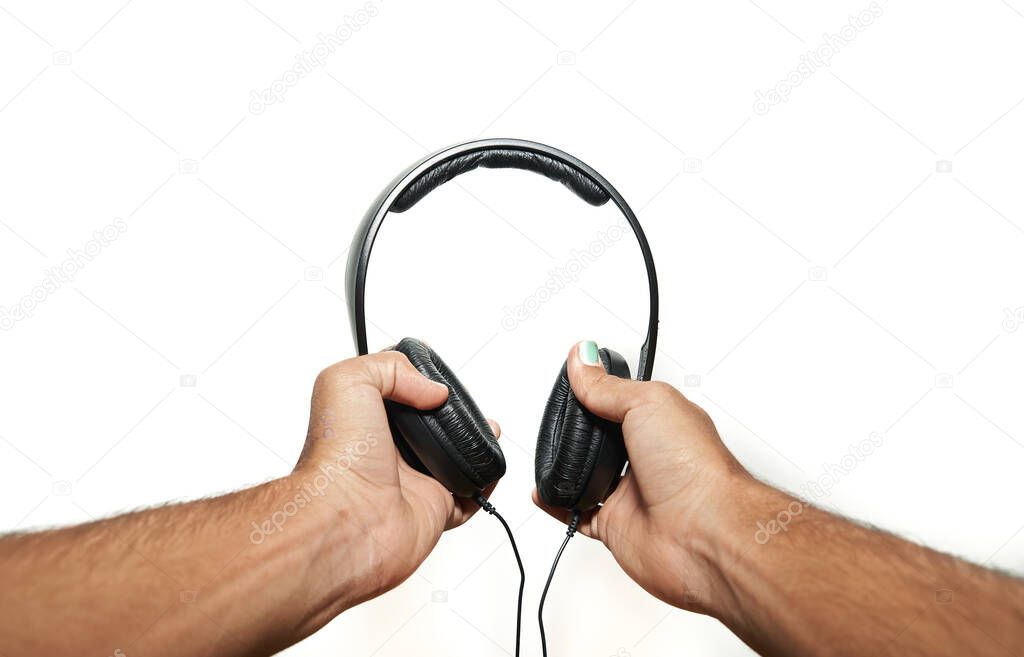 hands holding black Headphones on white background