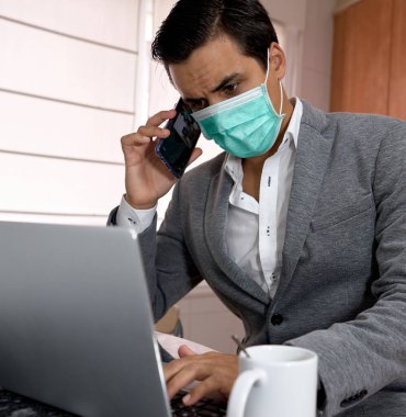 Çocuk maskeli, laptoplu ve iyi giyimli.