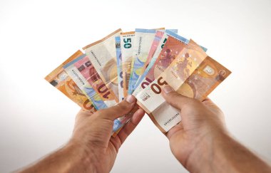 Beyaz arka planda çok para tutan eller.