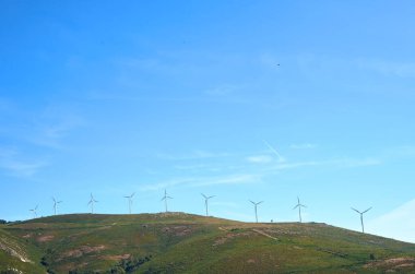 Yel değirmenleri ve mavi gökyüzü olan dağlar