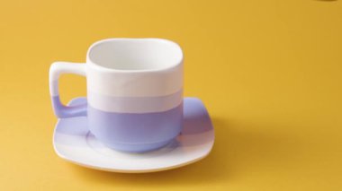 Turuncu arka planda kahve dolu bir fincan.