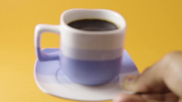オレンジの背景にコーヒーを出す手 — ストック動画