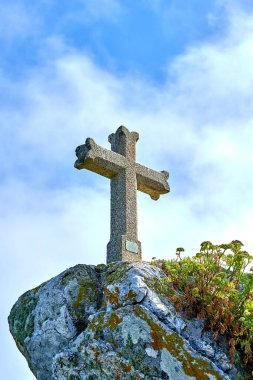 Taştan Hıristiyan haçı bulutlarla dolu bir dağın tepesinde