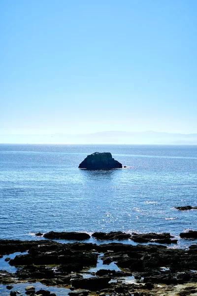 Mavi deniz ve berrak gökyüzü ile kayalık deniz manzarası