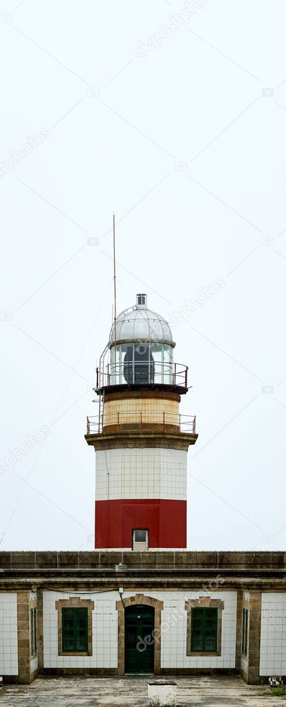 red and white lighthouse with cloudy sky