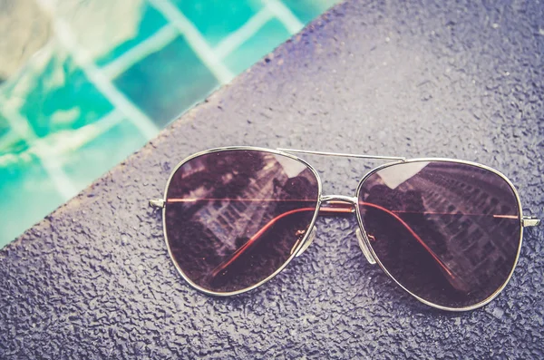 Brown funky sun glasses near swimming pool.Outdoor shot using natural light.