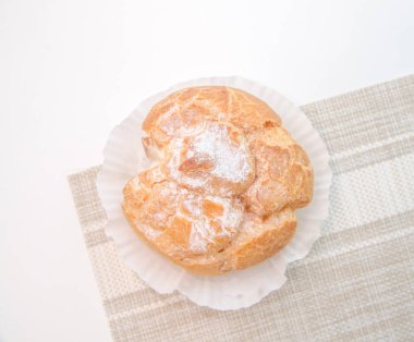 Kafede beyaz masa üzerine Pasta krema ile doldurulmuş profiterol 