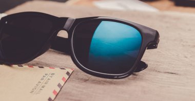 ahşap arka plan üzerinde mavi aynalı güneş gözlüğü yakın. Yatay