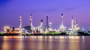 Yansıma ile alacakaranlıkta rafineri tesisi alanı (petrol, rafineri, sanayi)