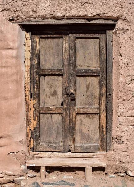 泥の壁にロックと古いと木製のドアを閉じる — ストック写真